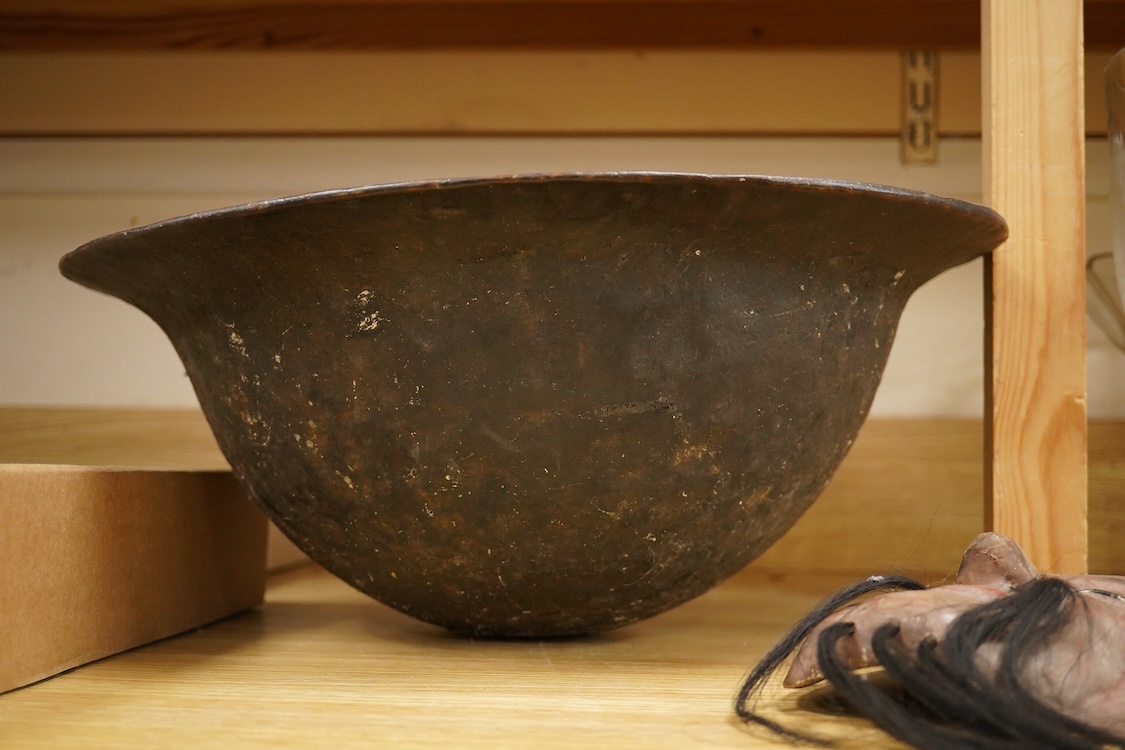 A wooden bowl with a decorative carved rim - 44cm wide across rim and an oriental carved and painted wooden face mask